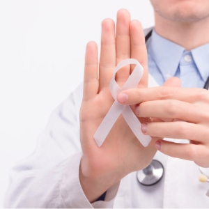 Médico sosteniendo cinta blanca en apoyo a la investigación clínica en cancer